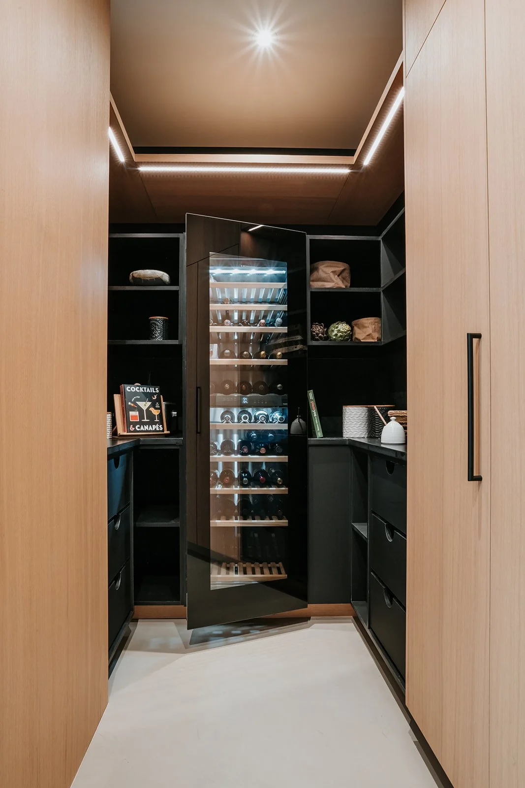 Sunstone Hidden pantry around the corner with full-height wine fridge, not behind a door — new-build interior design in Pemberton, BC by LRD Studio. Photography by Darby Magill.
