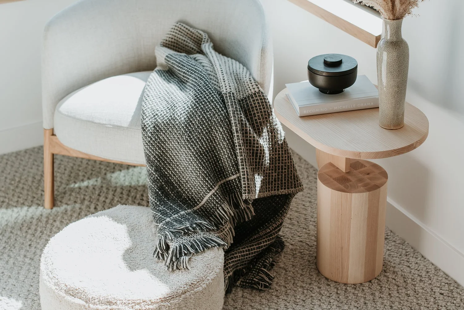 Balsam Accent chair with throw blanket, wooden mushroom side table, books, dried flowers — new-build interior design in Whistler, BC by LRD Studio. Photography by Darby Magill.