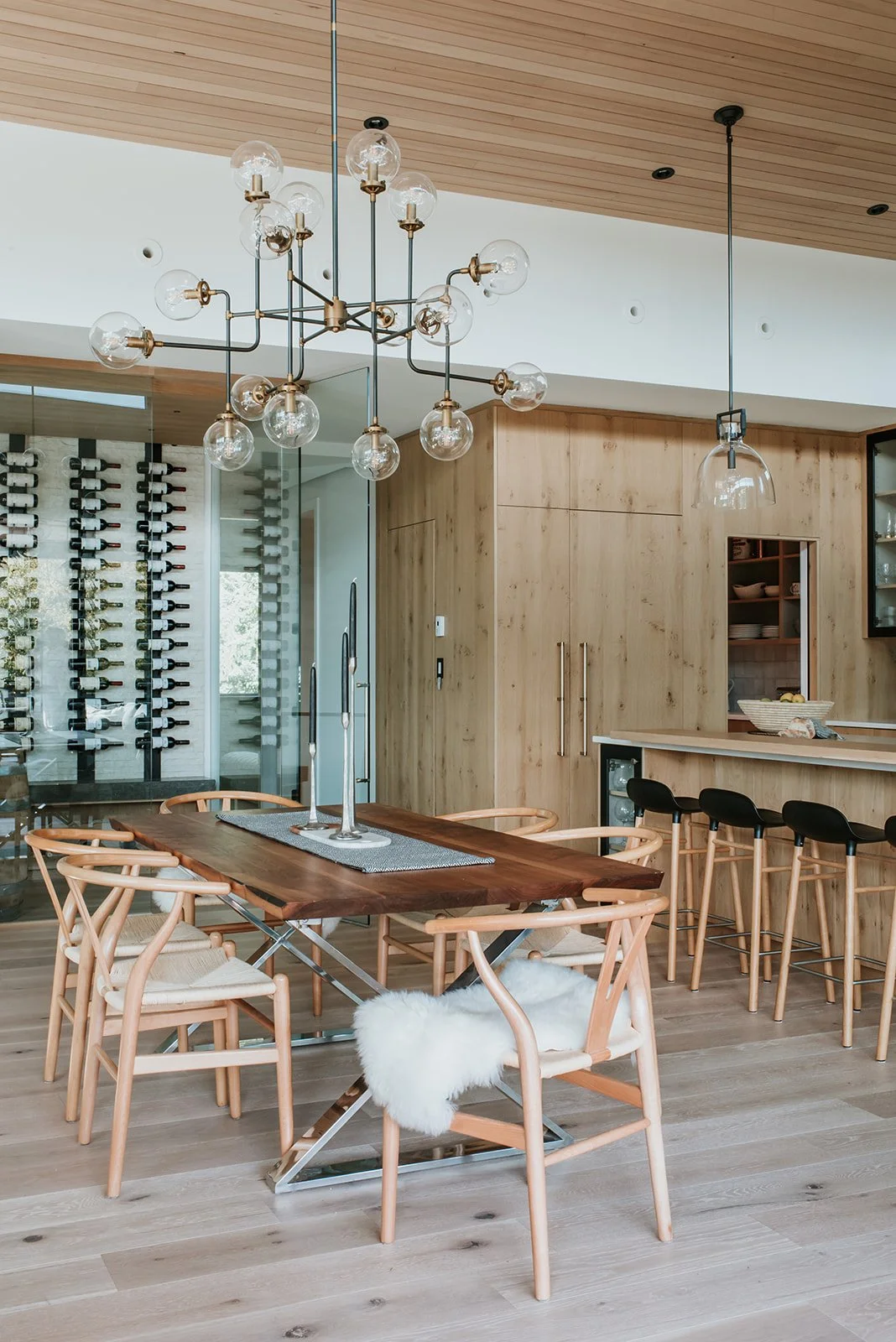 Balsam Live edge walnut table with chrome legs, wishbone chairs with sheepskin — new-build interior design in Whistler, BC by LRD Studio. Photography by Darby Magill.