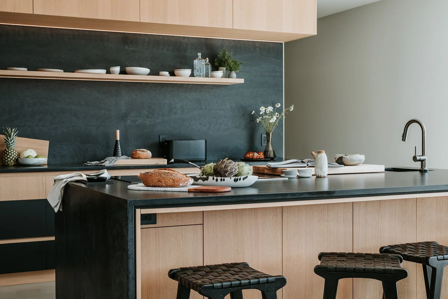 Sunstone Wide kitchen view with island, stools, full backsplash — new-build interior design in Pemberton, BC by LRD Studio. Photography by Darby Magill.