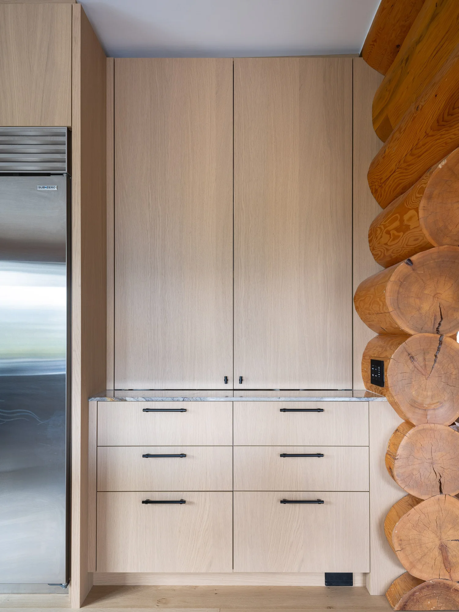 Sunridge Open shelving integrated with log timber wall — renovation interior design in Whistler, BC by LRD Studio. Photography by Matt Anthony.
