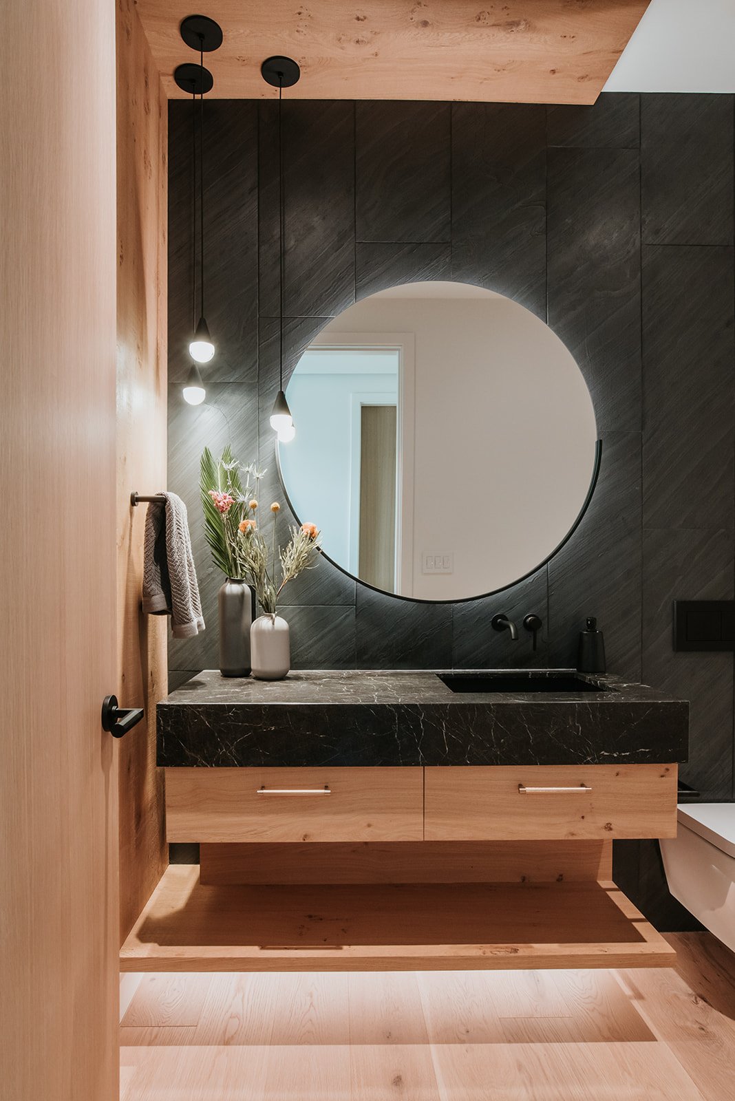 Balsam Oak floating vanity, wall-mount black faucet, oak-framed mirror, new-build interior design in Whistler, BC by LRD Studio. Photography by Darby Magill.