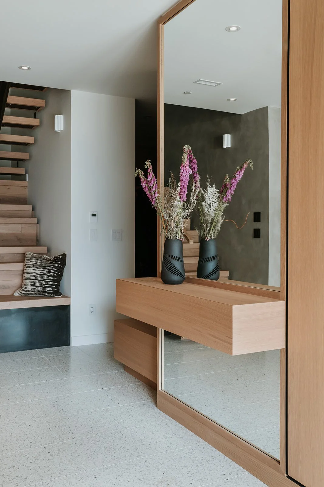 Sunstone Close-up of entry shelf with mitered-top hidden key drawer, flowers — new-build interior design in Pemberton, BC by LRD Studio. Photography by Darby Magill.