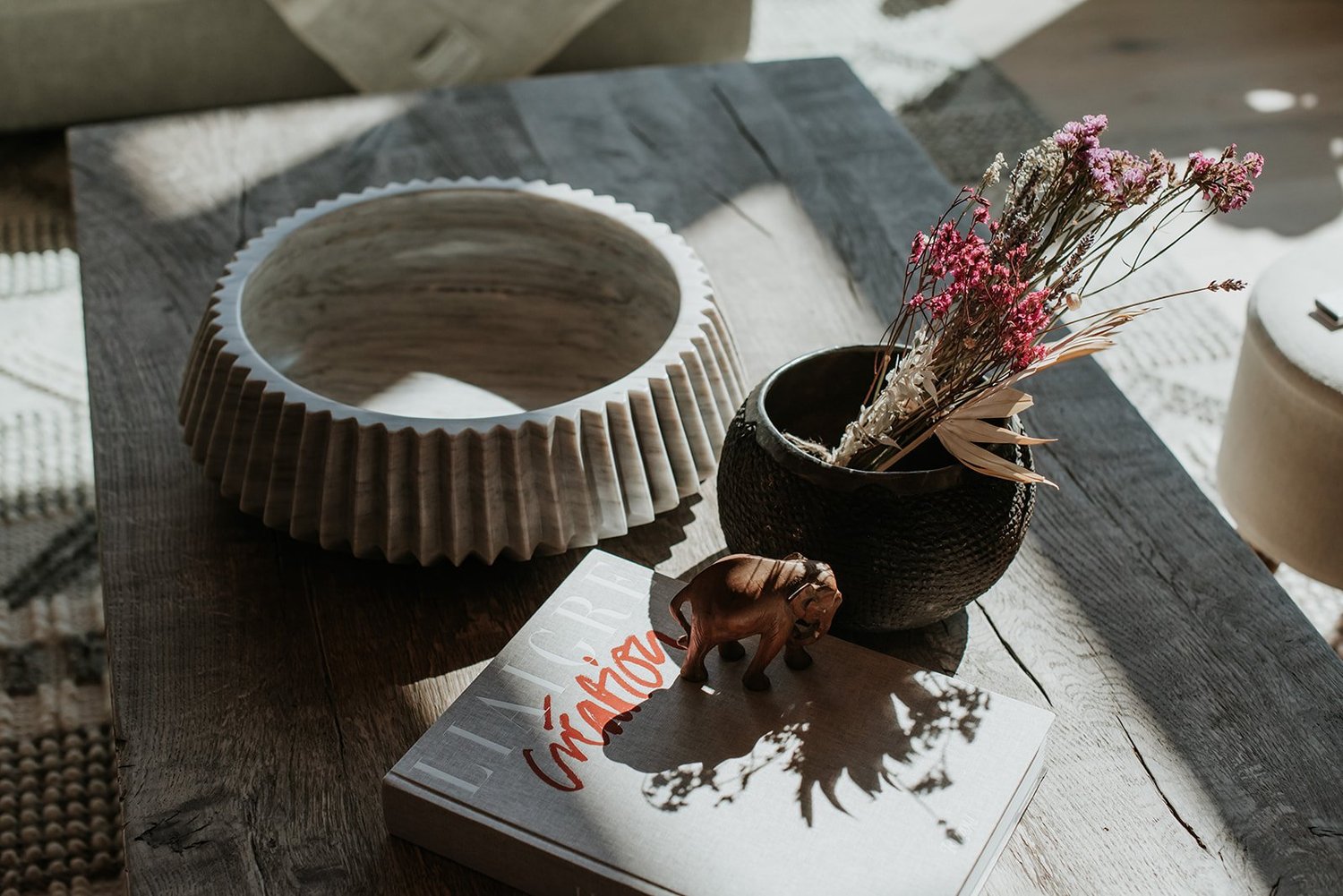 Balsam Coffee table detail: fluted ceramic bowl, dried flowers in textured black vase — new-build interior design in Whistler, BC by LRD Studio. Photography by Darby Magill.