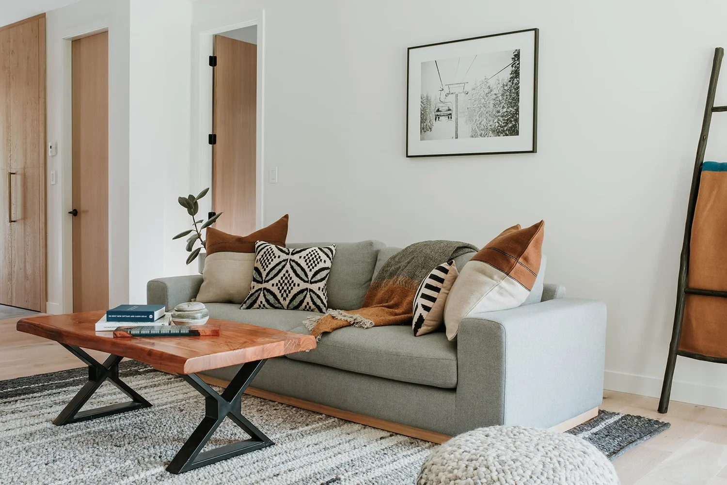 Balsam Grey sofa with cognac/patterned pillows, live edge coffee table — new-build interior design in Whistler, BC by LRD Studio. Photography by Darby Magill.