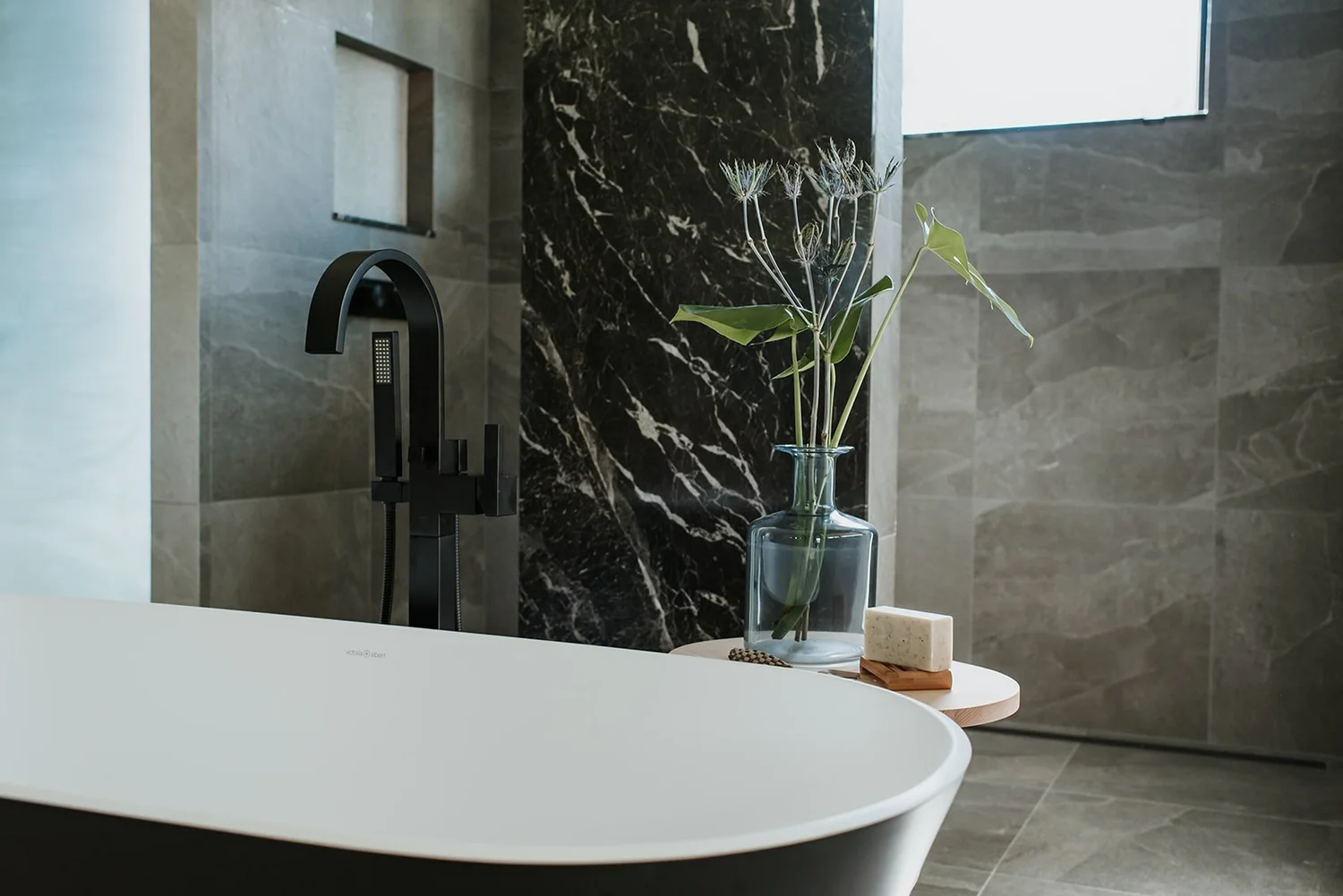 Balsam Freestanding black tub close-up, black arch faucet — new-build interior design in Whistler, BC by LRD Studio. Photography by Darby Magill.