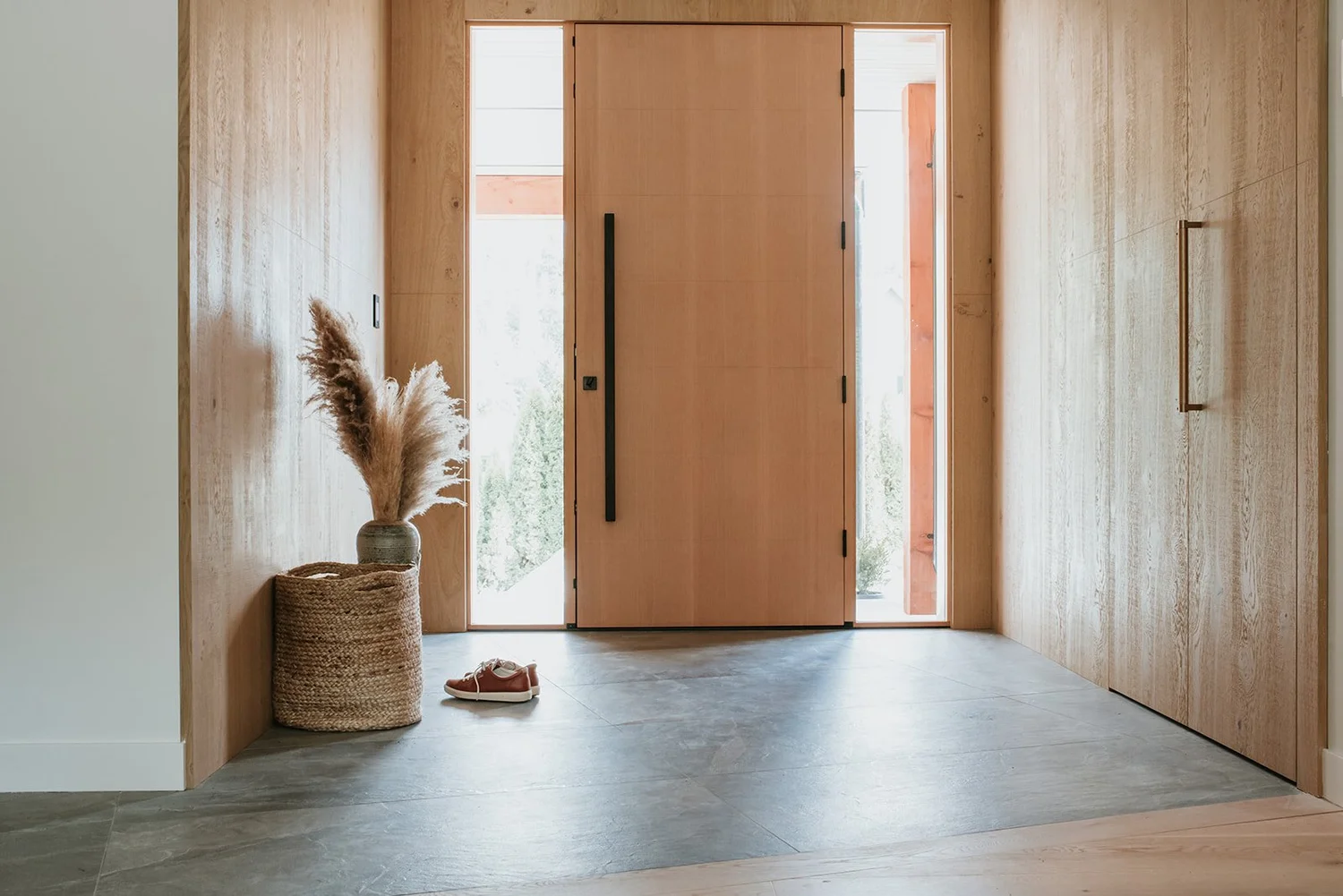 Balsam Entry with concealed paneled storage (invisible handles), angled floor tiles visible — new-build interior design in Whistler, BC by LRD Studio. Photography by Darby Magill.