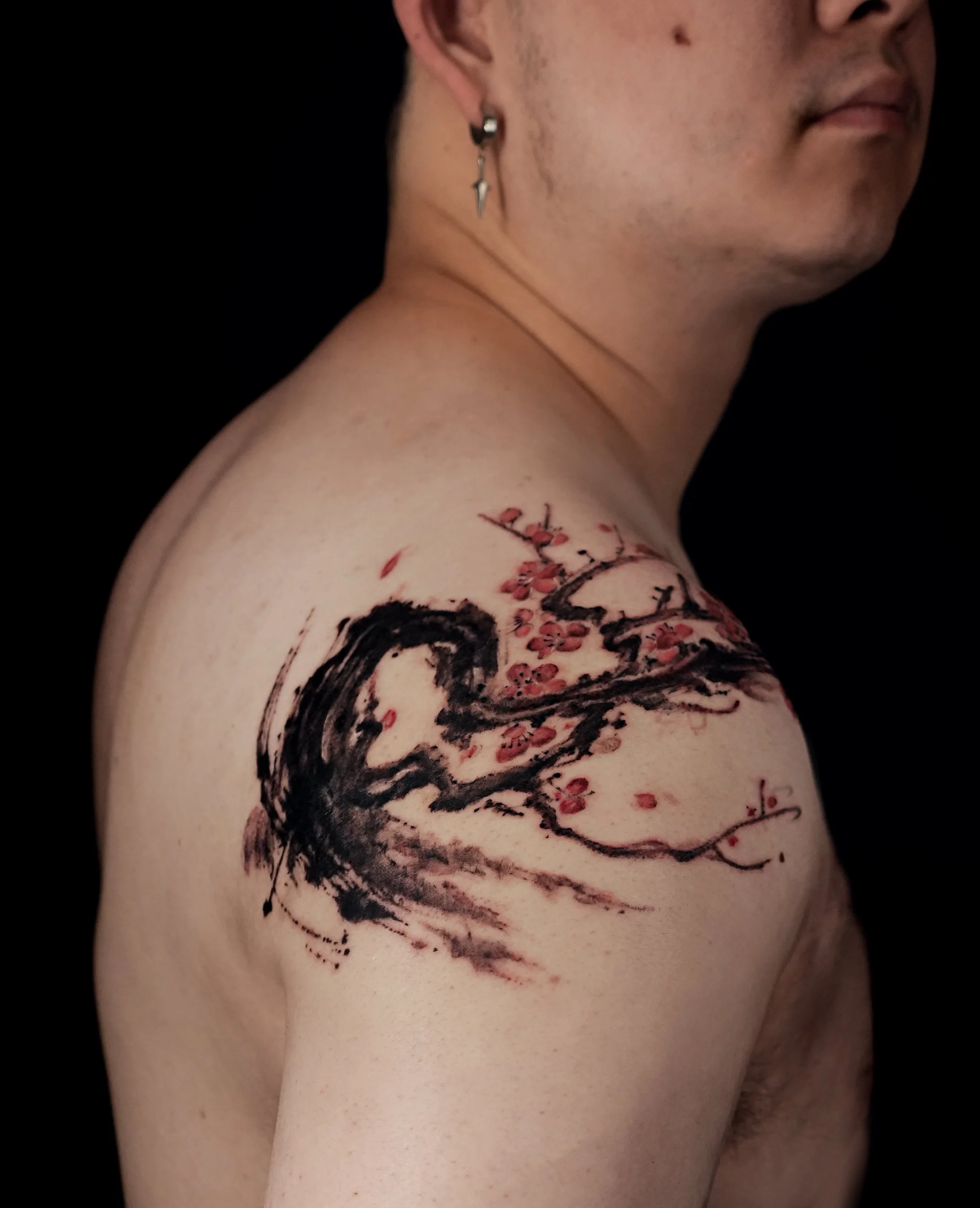 Plum blossom tattoo on shoulder with strong sumi-e brush stroke style. Art piece by kaho inkshop located in los Angeles, california