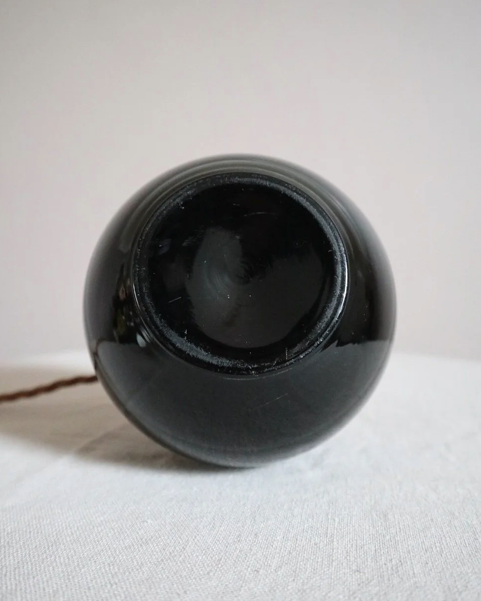 Small, Art Deco black glass ball lamp in the style of Jacques Adnet. Circa 1930s.