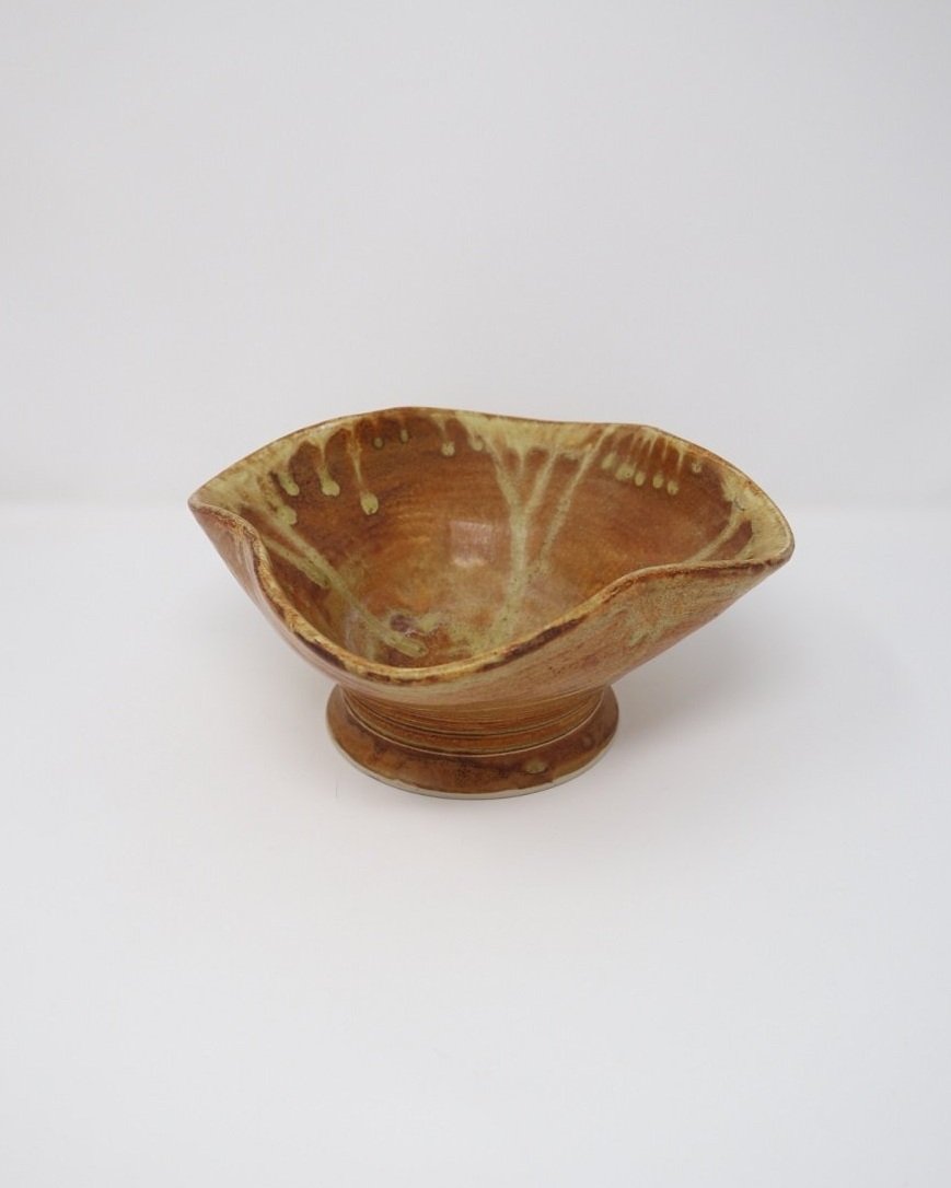 tage, handmade studio pottery ceramic bowl with wavy edge and brown, orange and ochre glaze. Marked Baughan 1997 to base.