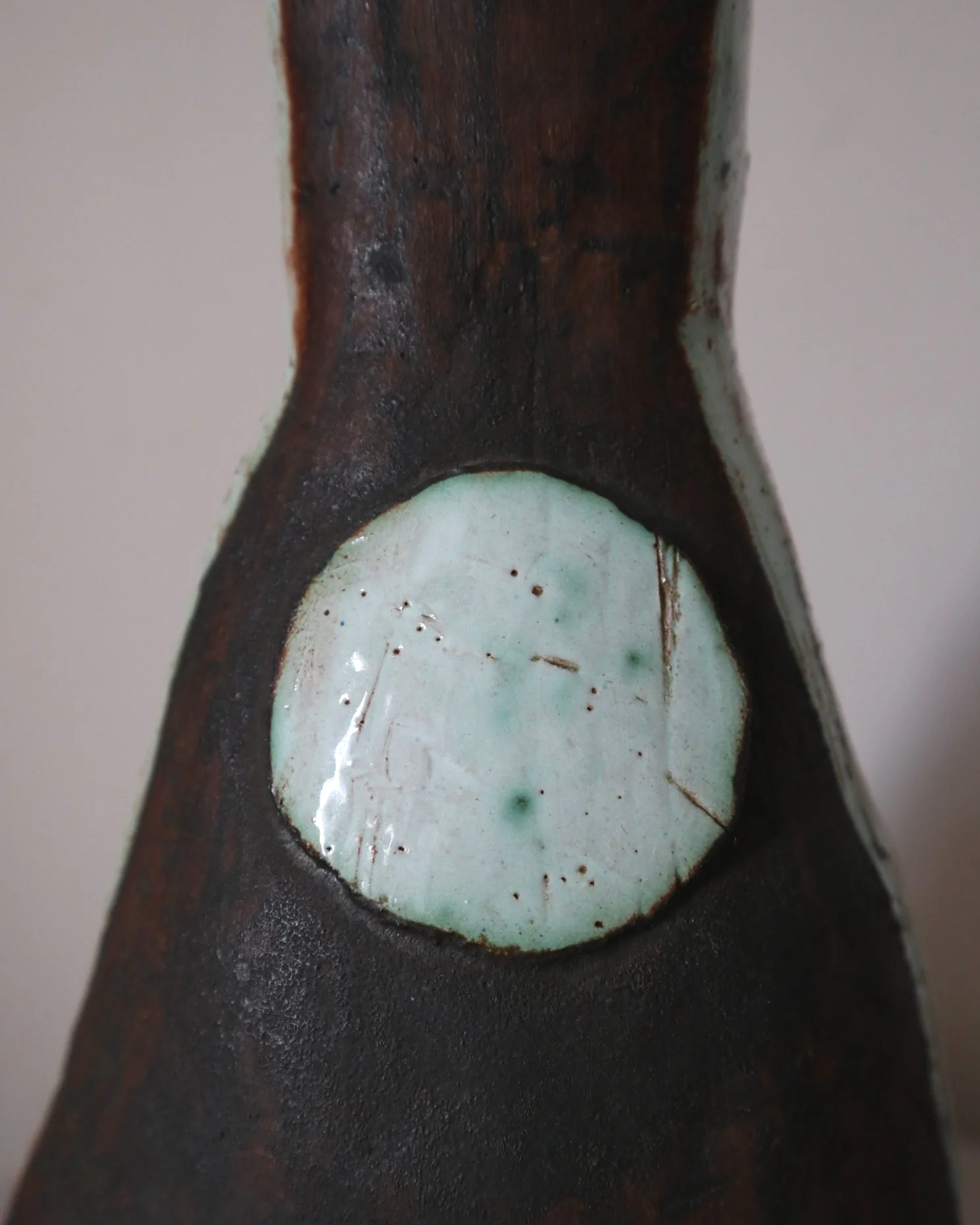 Vintage hand-built ceramic Brutalist art vase, featuring an abstract, asymmetrical design with textured white, dark brown, and subtle green glazes.