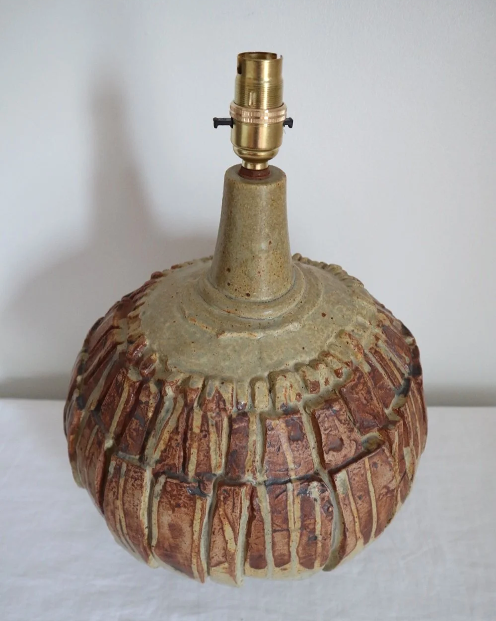 Large mid century Brutalist Bernard Rooke spherical art pottery table lamp with graduated slab sections and matt brown glaze. England, circa 1960s.