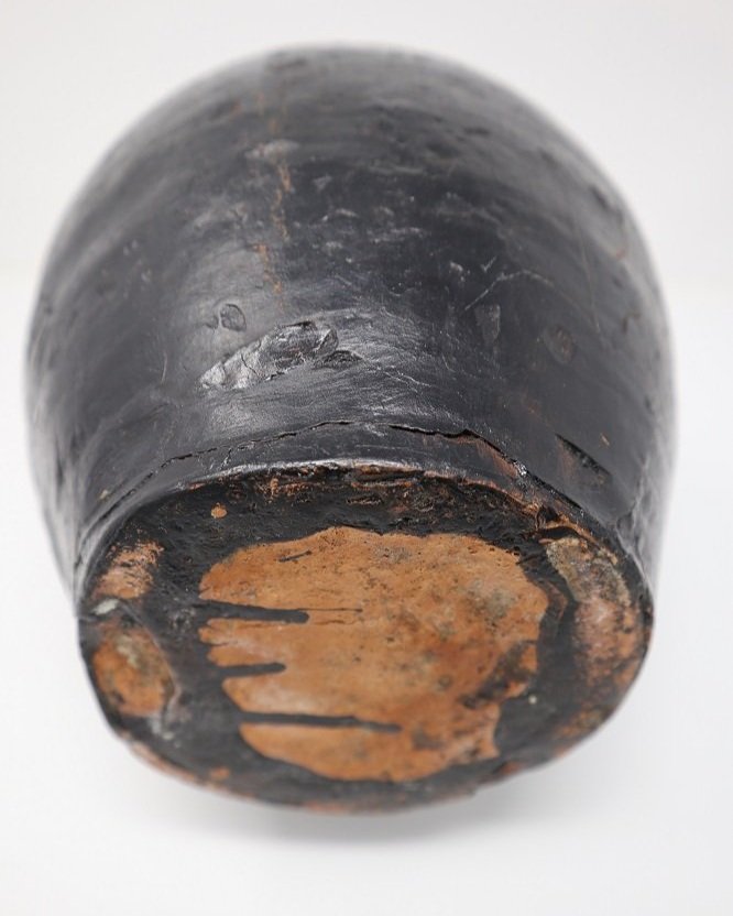 Vintage aged, rustic black painted earthenware pitcher vessel from Hungary with simple line detailing and curved handle.