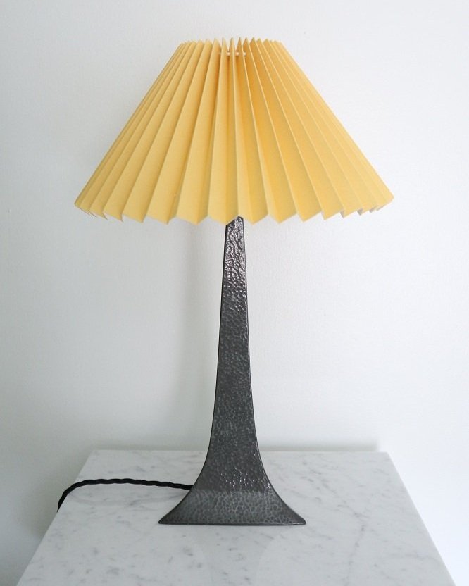 Vintage hammered pewter Arts and Crafts lamp with a graceful, thin neck tapering to a triangular base. Comes with optional new, butterscotch yellow pleated coolie shade. 1920s or 1930s.
