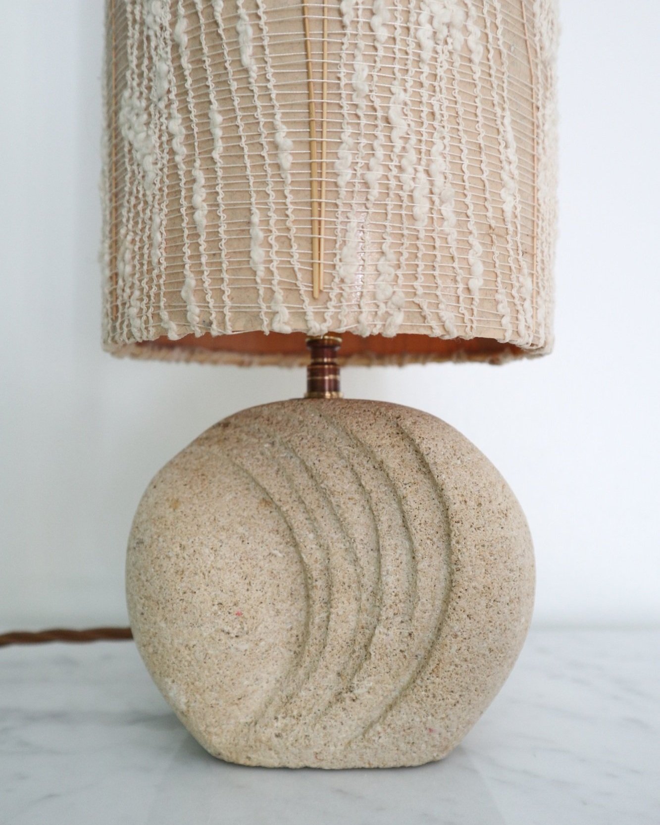 Small, French carved textured limestone round table lamp in the style of Albert Tormos. Circa 1970s