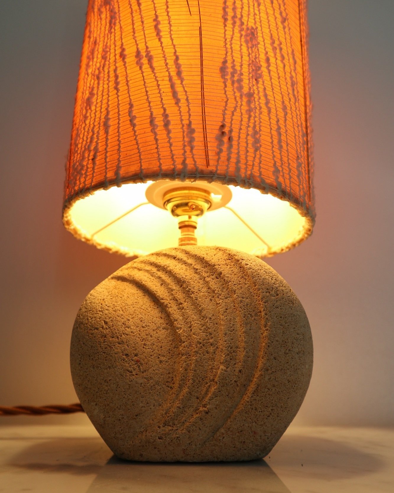 Small, French carved textured limestone round table lamp in the style of Albert Tormos. Circa 1970s
