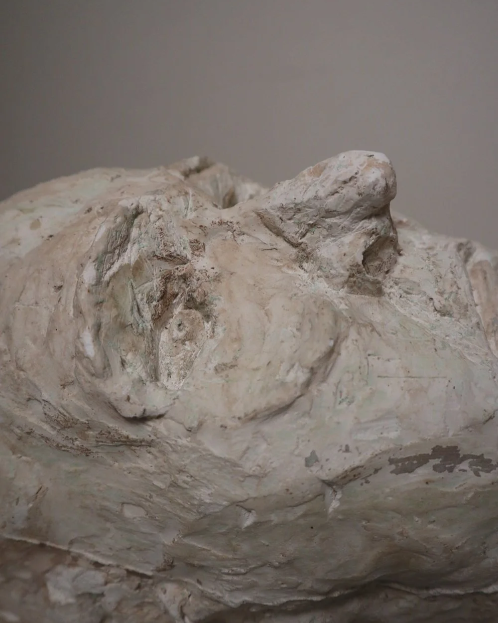 Large, heavy off white textured plaster sculpture of man's head in abstract style. Unknown age.