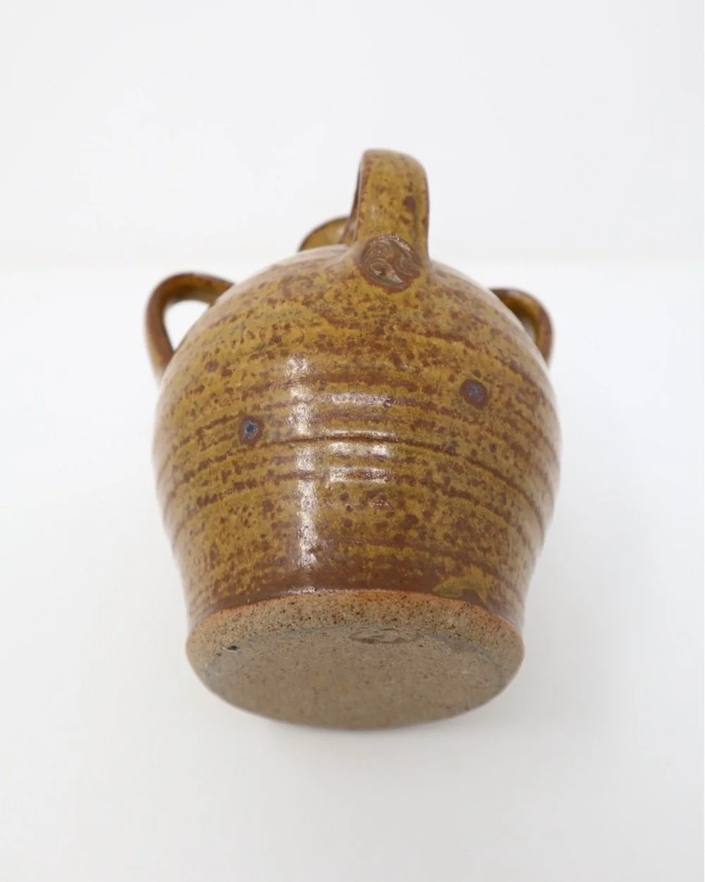 Small studio pottery four handled stoneware vase with mottled brown glaze and three pronged markings.
