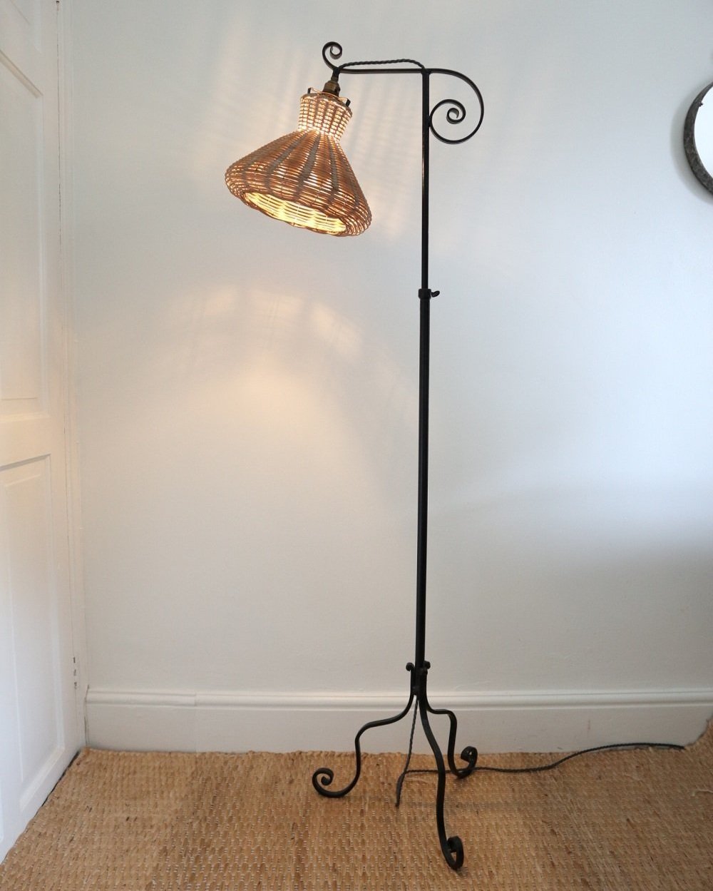 Wrought iron decorative reading floor lamp with rattan shade. Lamp base circa 1940s.