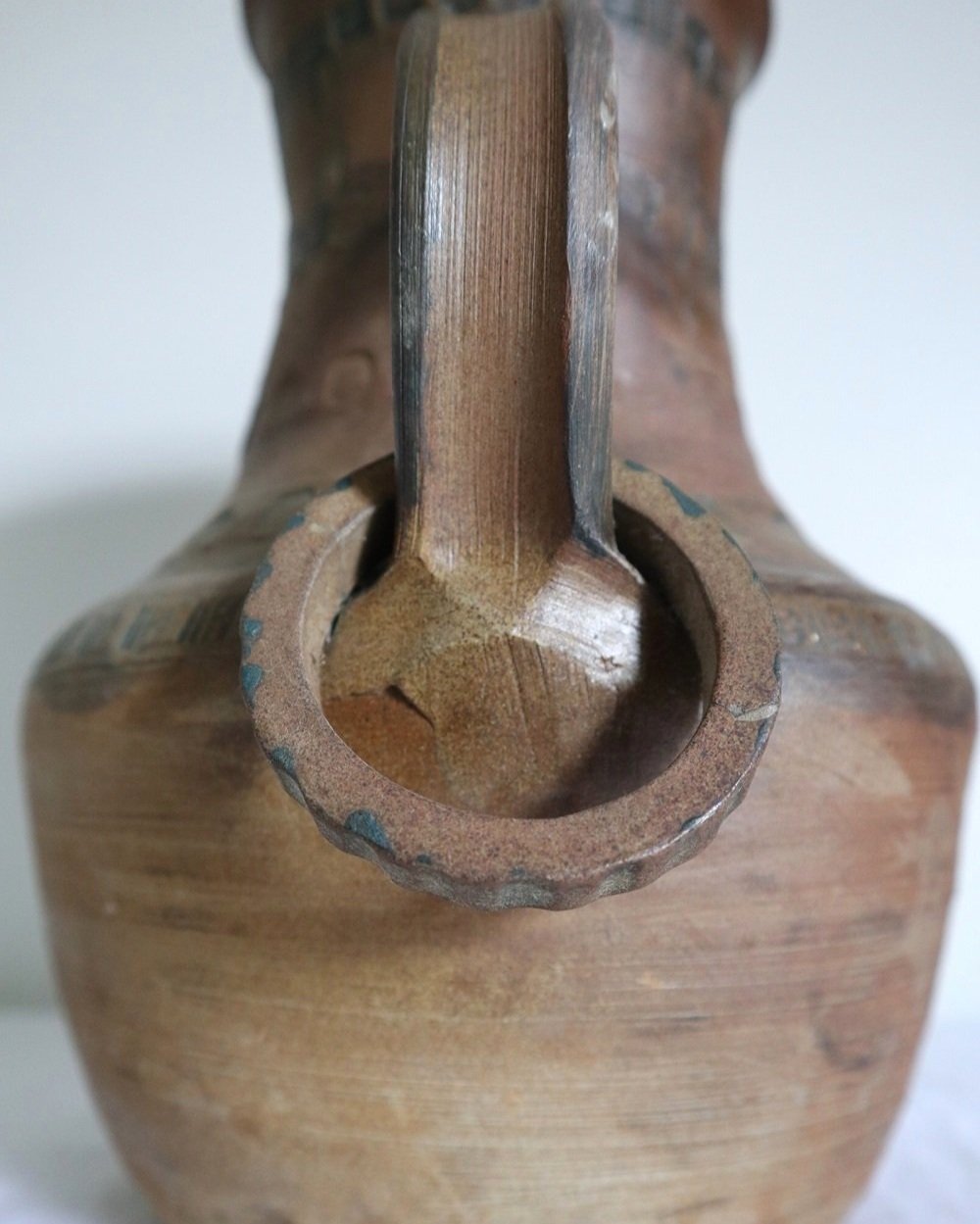 Vintage two handled heavy studio pottery stoneware vase with imprinted decorative bands and two rings on handles.