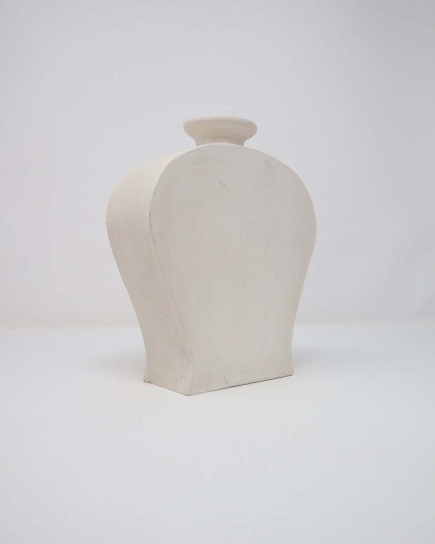 Pair of sculptural flat, matt white, untreated clay vases of simple form.