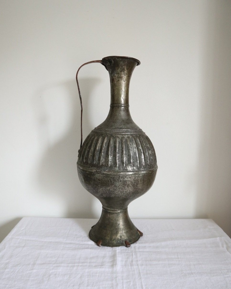 A 19th century tin metal Islamic ewer with thin decorative handle. With beautiful patina and sculptural detail.
