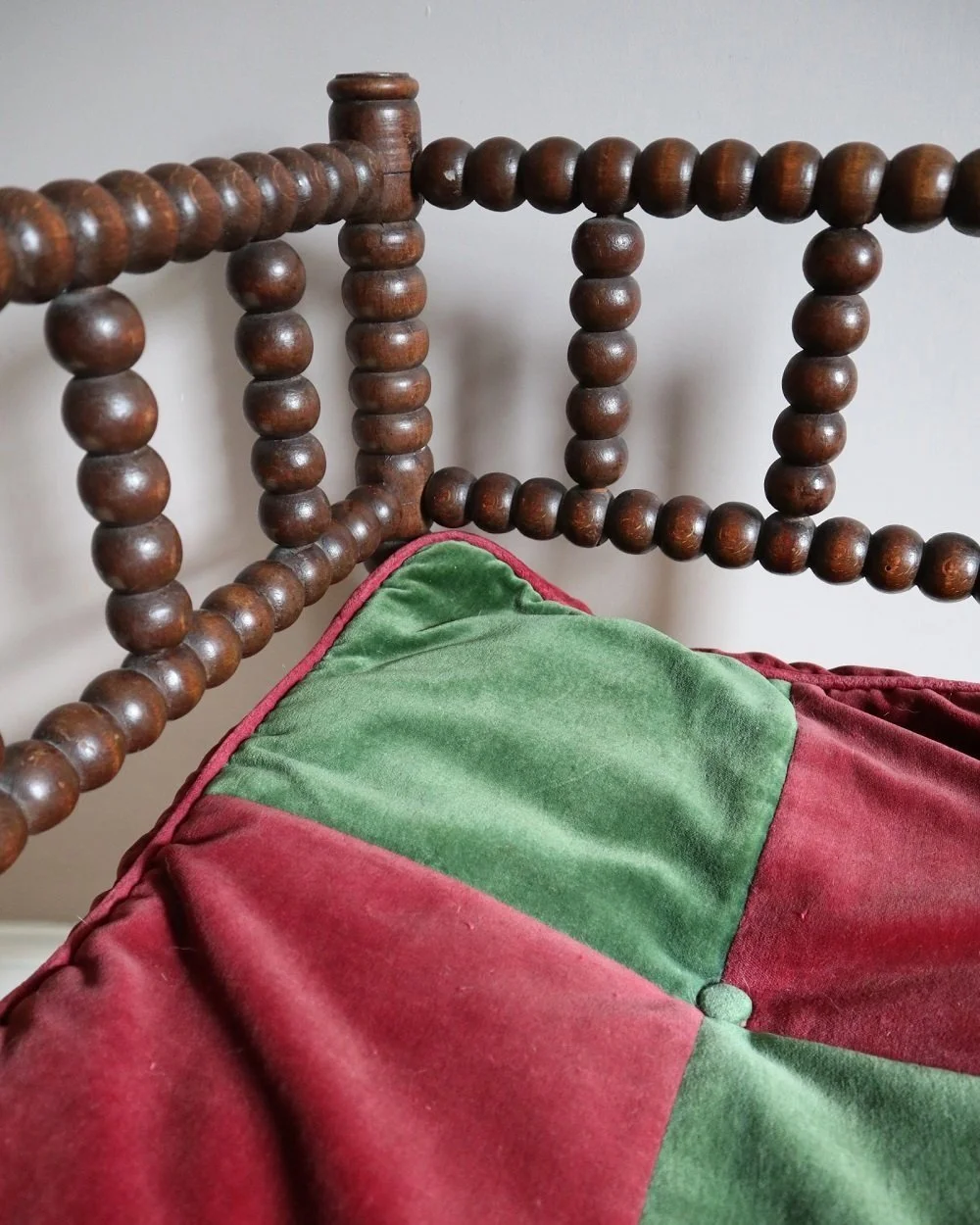 Characterful antique bobbin corner chair with interwoven red and natural rush seat and charming green and red velvet seat cushion. Circa 19th Century.