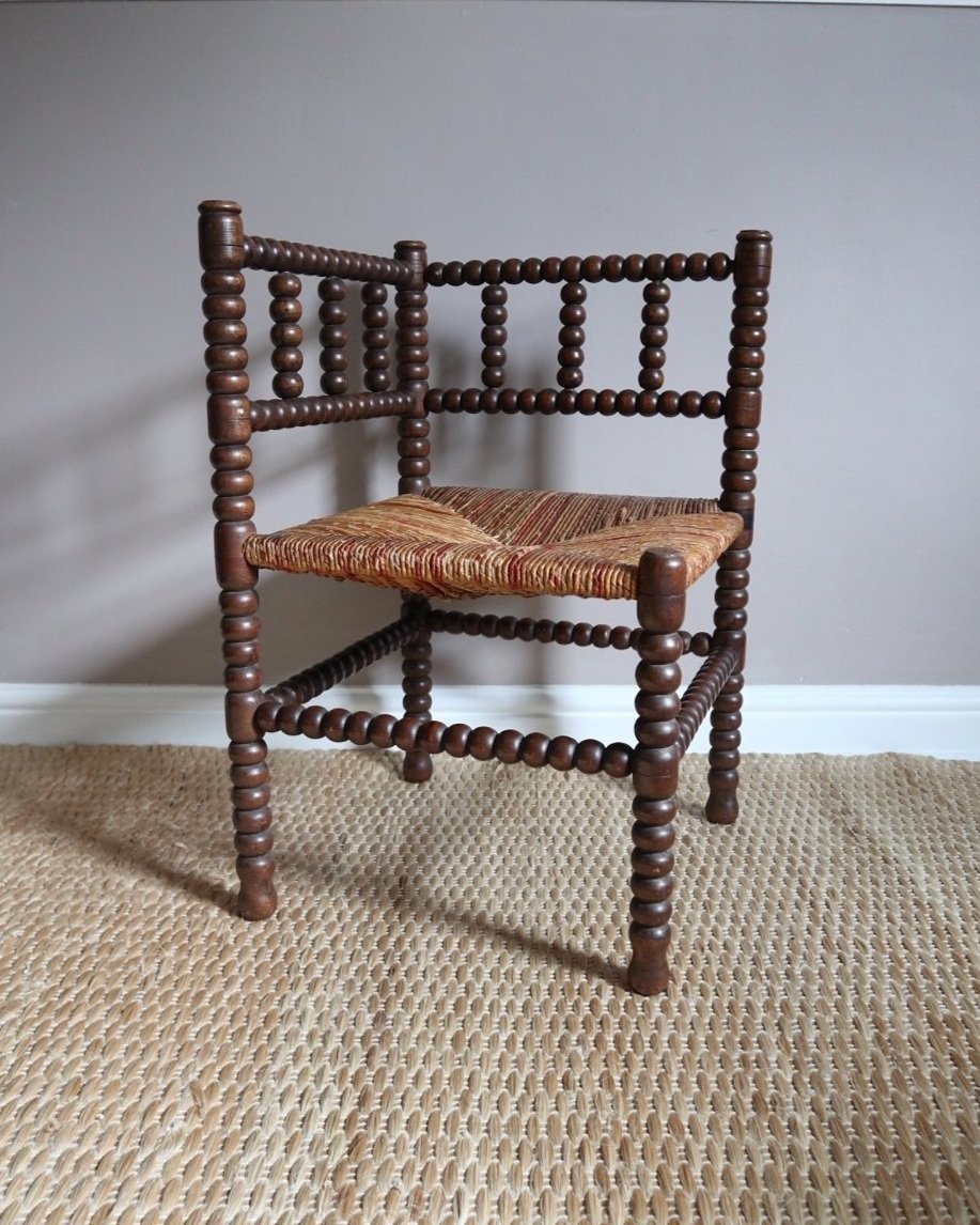 Characterful antique bobbin corner chair with interwoven red and natural rush seat and charming green and red velvet seat cushion. Circa 19th Century.