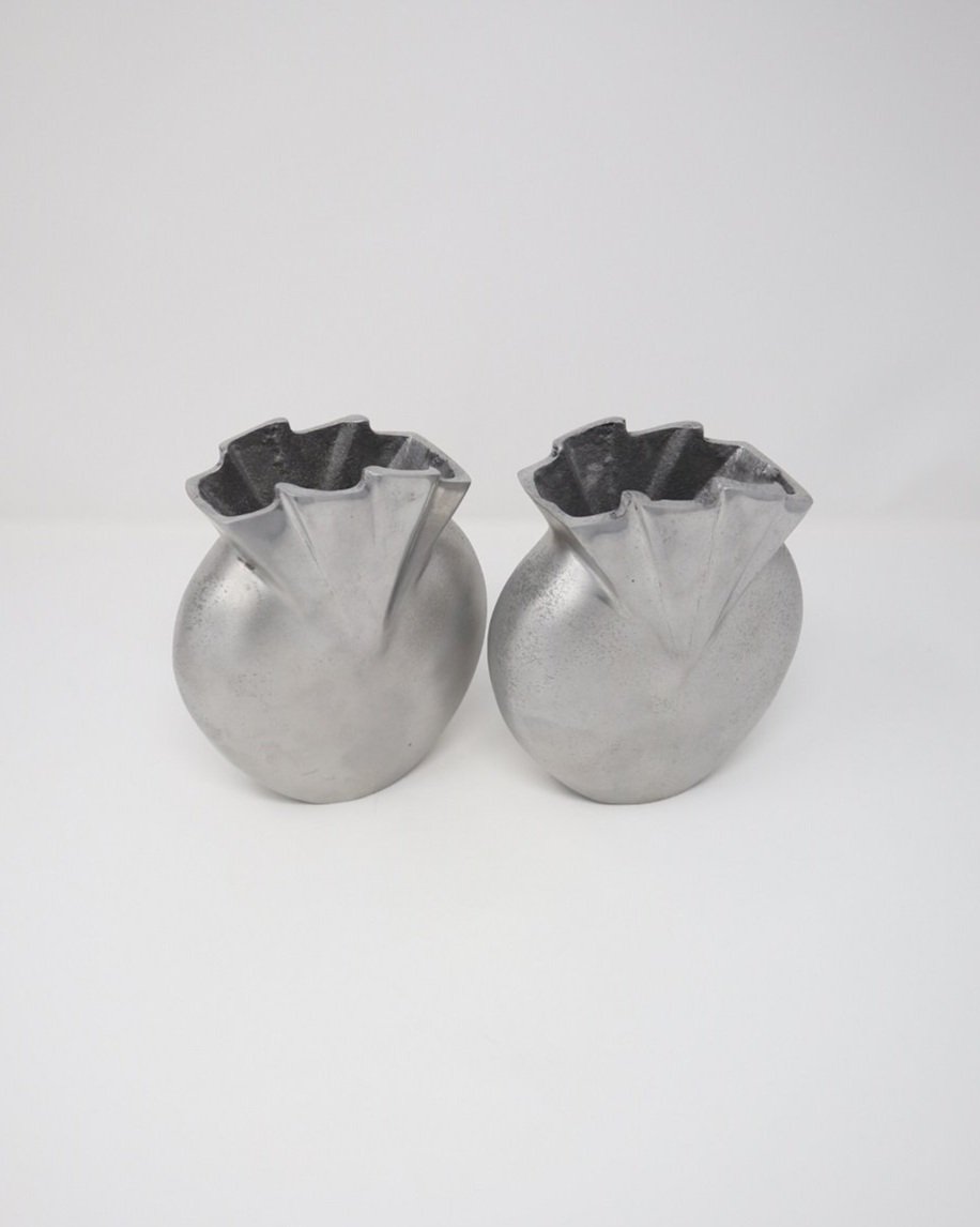 Contemporary style silver coloured cast metal round vases with pleated top.