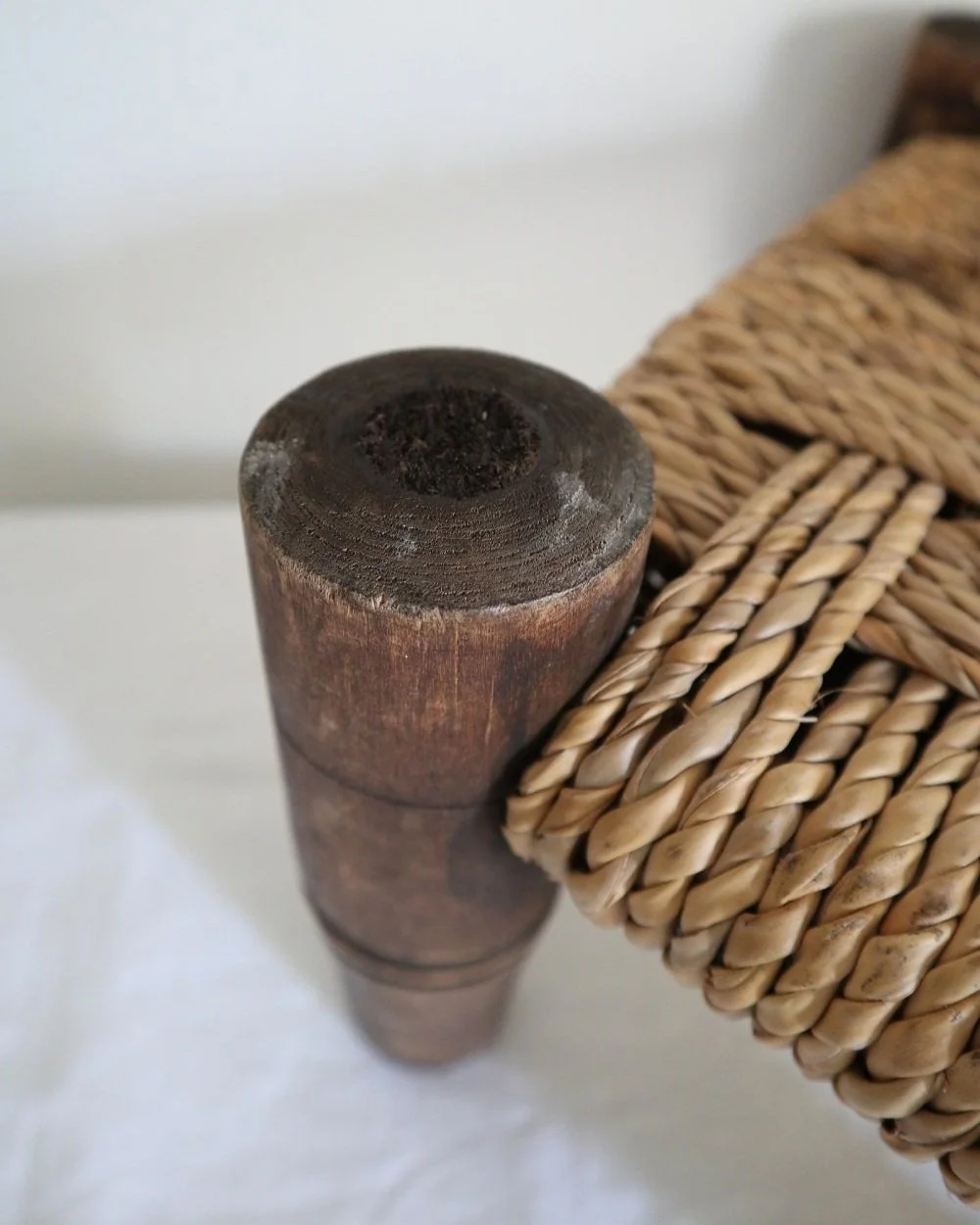 20th Century small woven rope footstool with thick turned wooden legs. In the style of Audoux & Minnet, France.