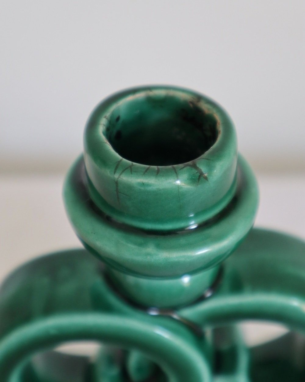 Striking jewel green glazed ceramic candleholder with intertwined circles. Similar to the designs from Vallauris, France.