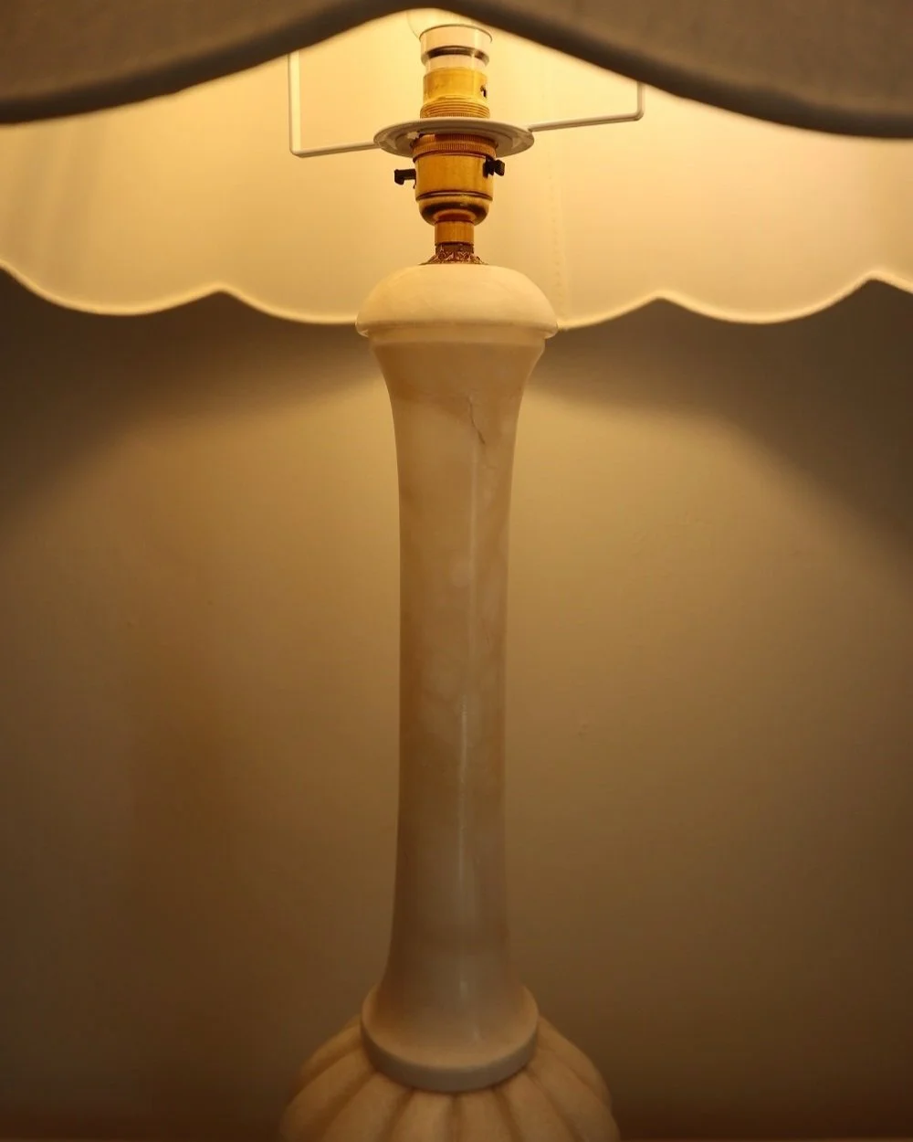Elegant, tall and heavy carved white marble table lamp with ornate brass detailing. Comes with new, white cotton scallop shade.