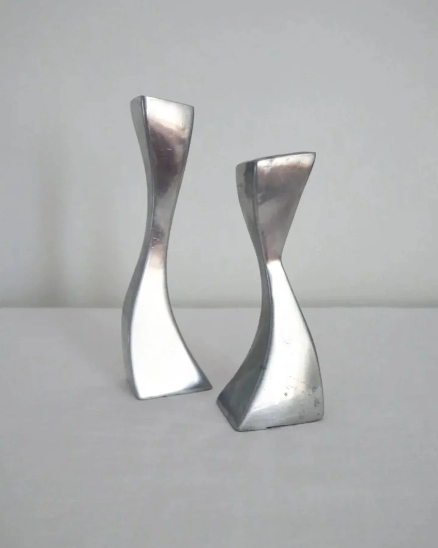 Available online ~ Pair of Modernist style solid aluminium wiggly candleholders. 

In vintage condition, with visible wear and tarnishing in areas. See website for more images.

No makers marks. 

Tall: H19cm / Base D5.5cm x 4cm
Small: H15.5cm / Base