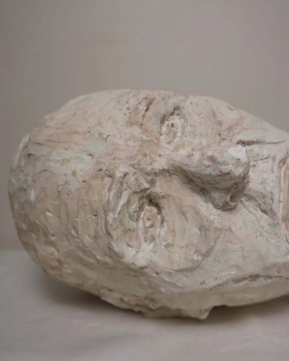 Large, heavy off white textured plaster sculpture of man's head in abstract style. Unknown age.