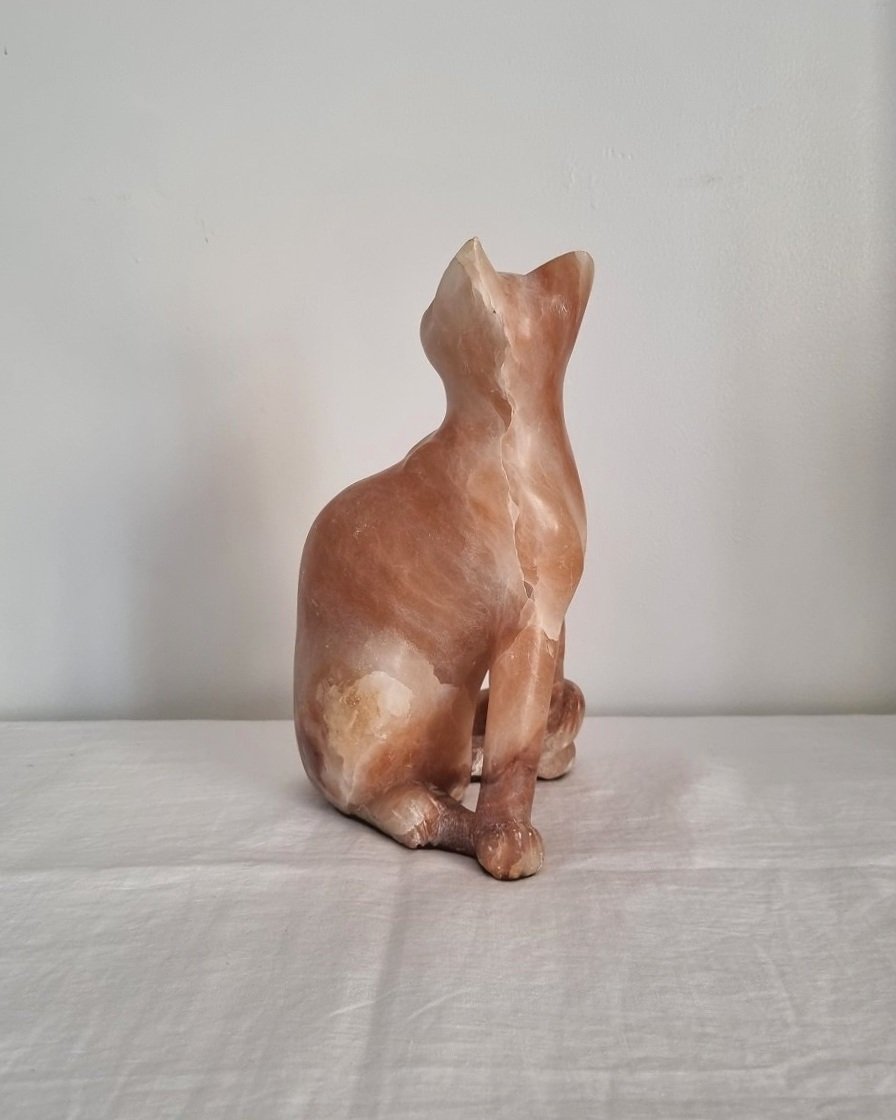 Vintage, heavy hand carved soft pink alabaster cat with striking natural grain and smooth lines.