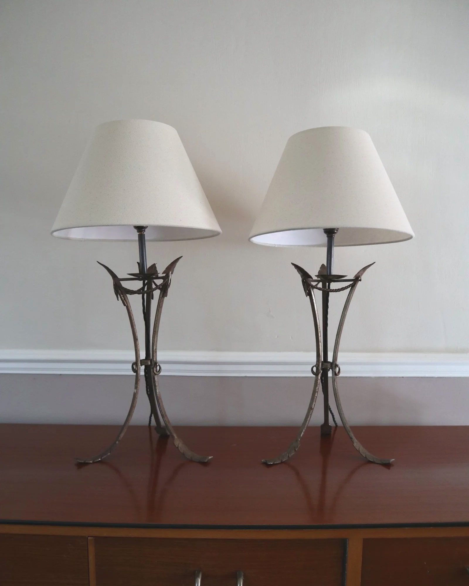 Pair of French style mid century metal tripod table lamps featuring three arrows.