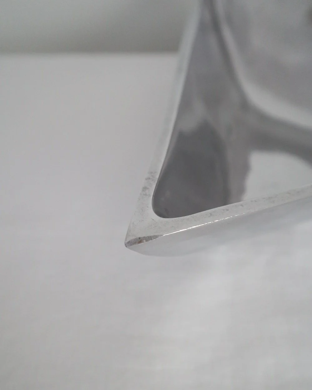 Solid shiny aluminium triangular Modernist style dish.