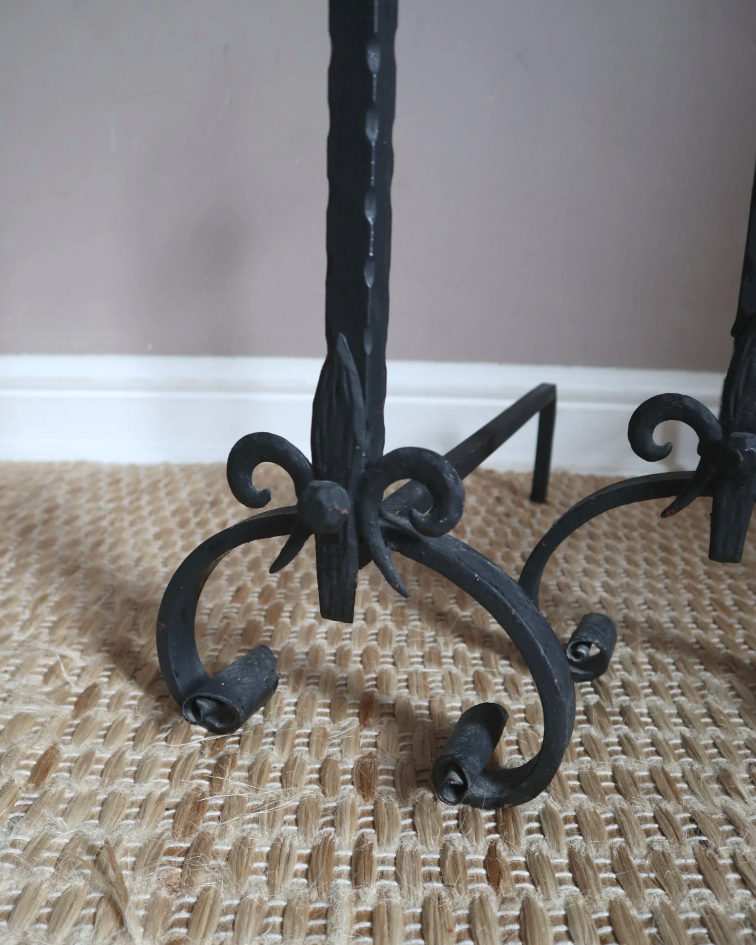 Pair of black wrought-iron andirons or firedogs featuring stylized rooster finials, circa mid-20th century.