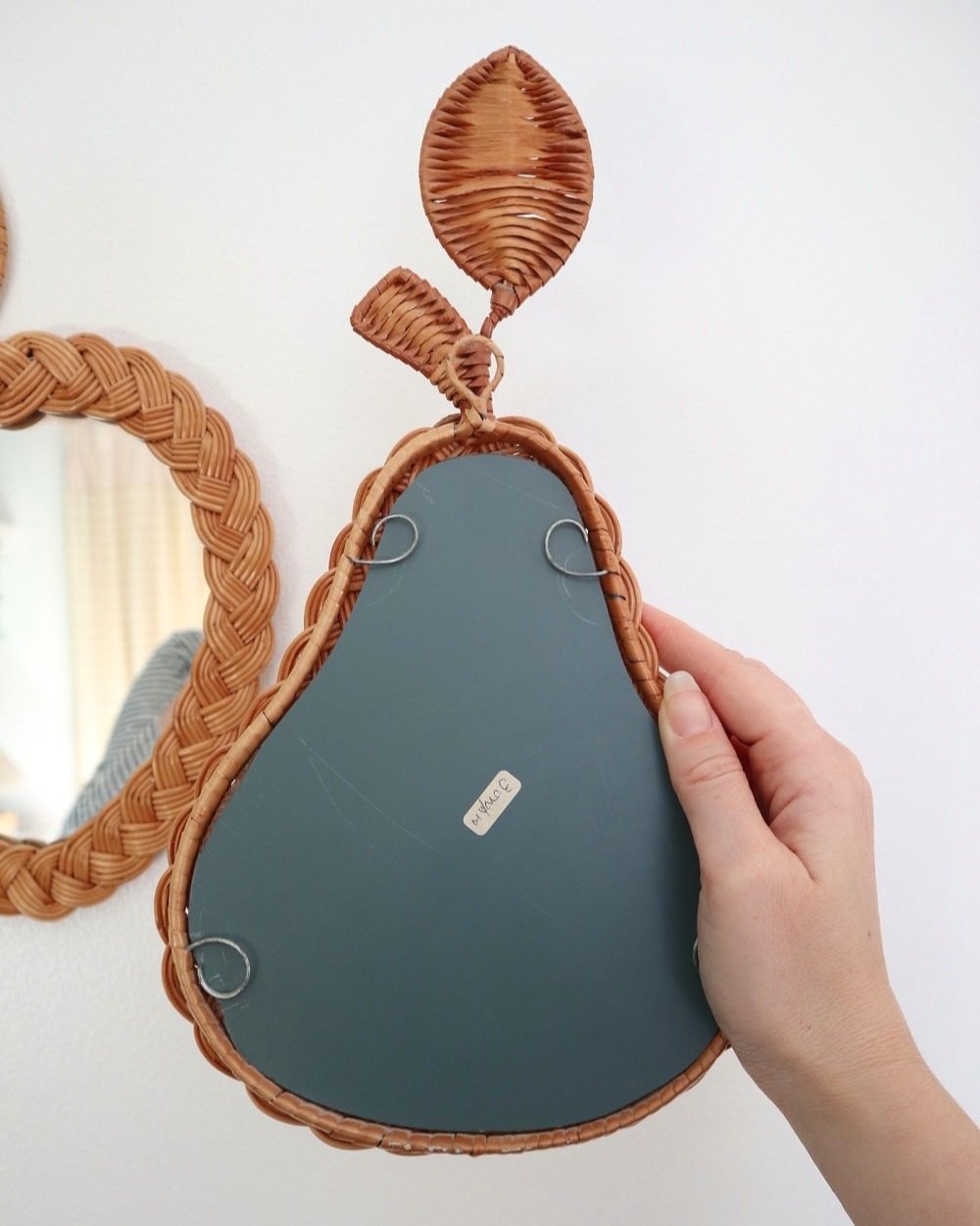 Pair of vintage small wall mirrors in the shape of an apple and a pear, with woven wicker frames.