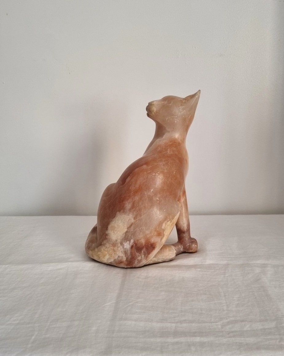Vintage, heavy hand carved soft pink alabaster cat with striking natural grain and smooth lines.