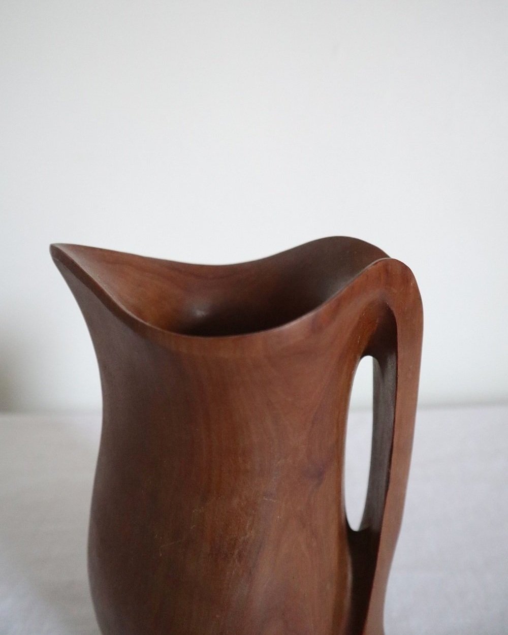 Small sculptural hand carved dark olivewood monoxyl pitcher, circa 1960/70s. In the manner of Alexandre Noll. Unsigned.