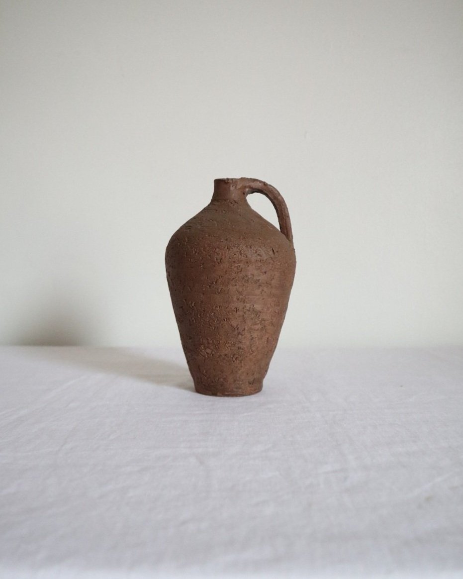 Mid century Brutalist sculptural textured brown ceramic decorative vessel or bud vase. Circa 1970s. Signed “CP”, likely the work of American potter Karl Martz for Clayburn Pottery.