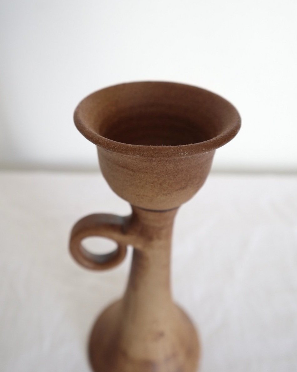 Rustic handmade studio pottery sculptural candleholder with curled circular handle.