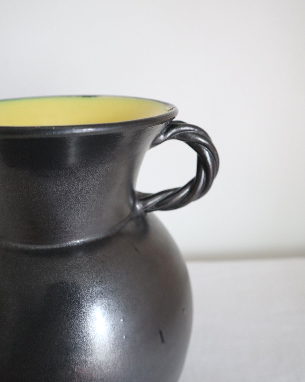 Large glossy, metallic black vase with double twisted handles and contrasting, yellow crackled glaze interior. Typical of Elchinger productions, France. Circa 1950s