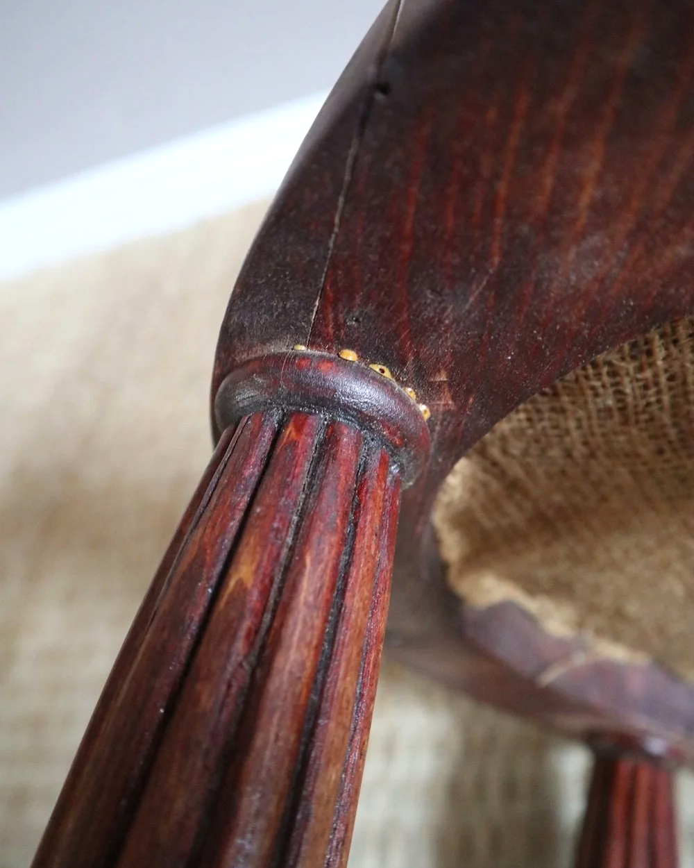 Antique Regency style carved wooden stool with four reeded tapered legs and dusky pink patterned upholstered seat.