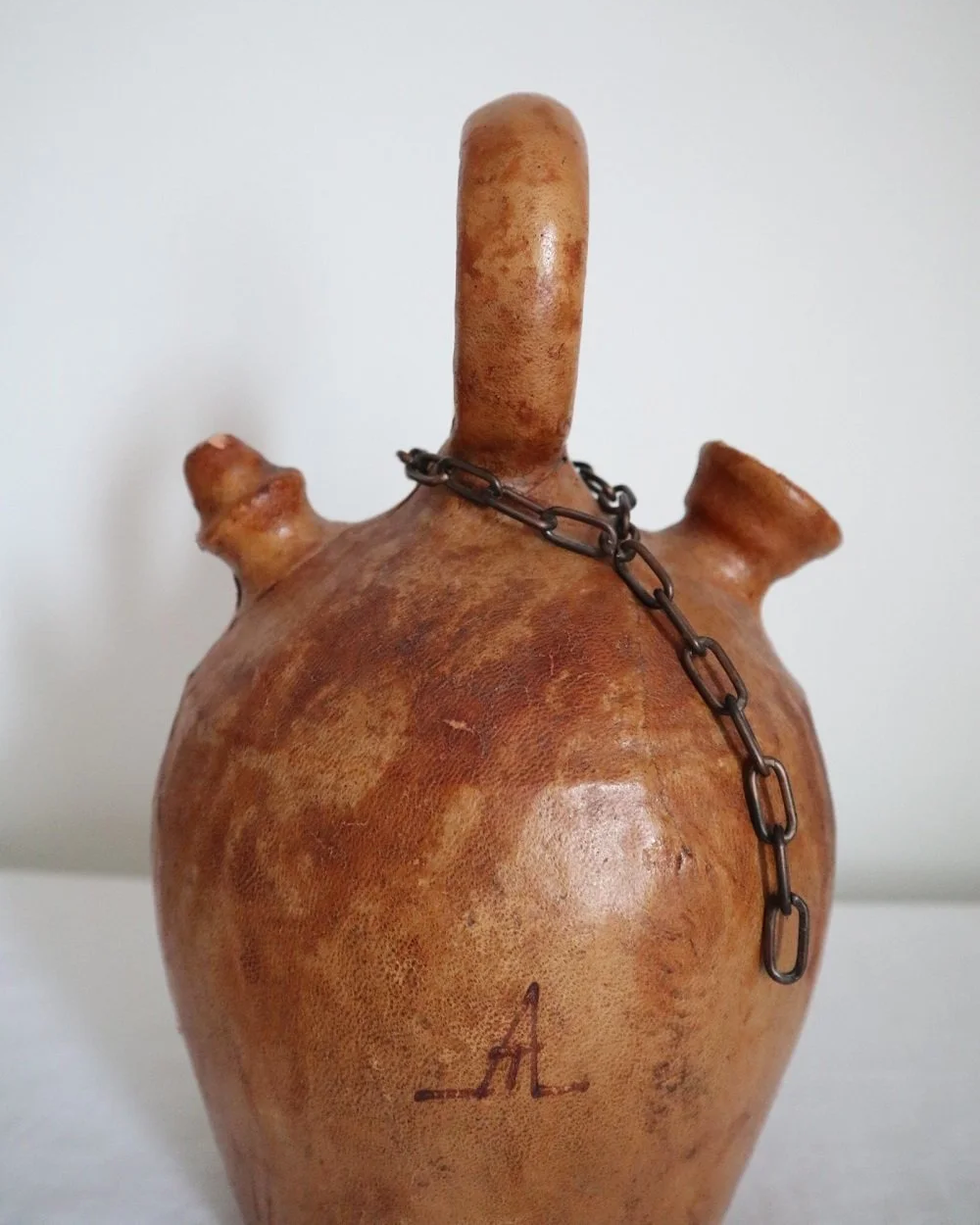 Spanish distressed tan leather covered oil or water pourer.