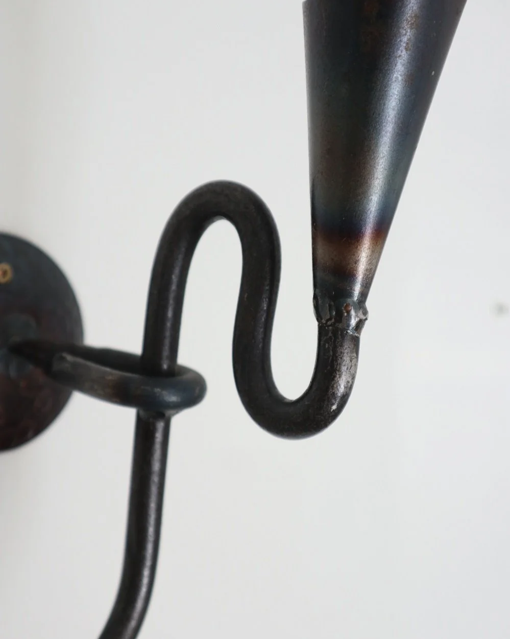 Large Swedish black iron wall sconce candleholder with wavy design. Circa 1960s.