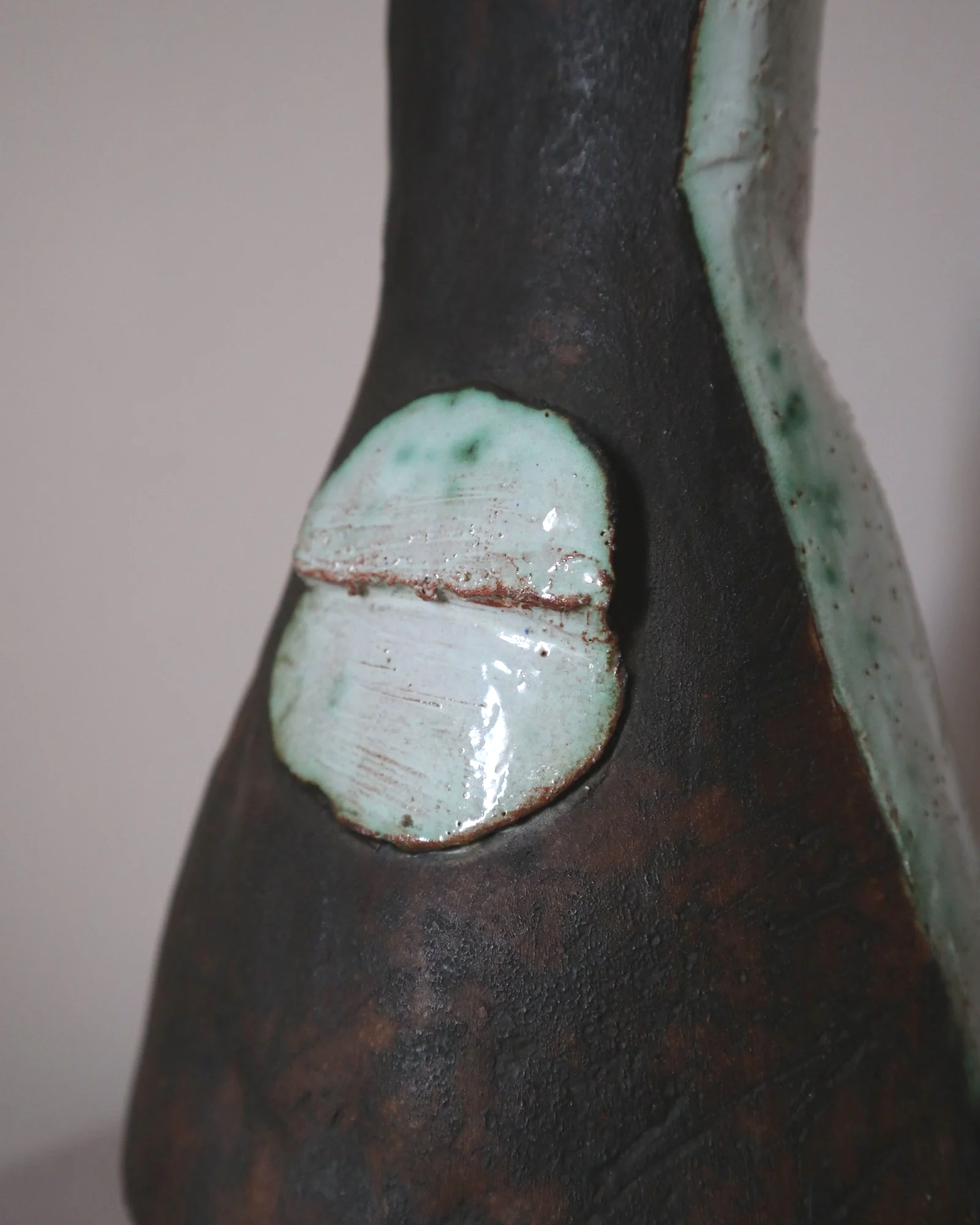 Vintage hand-built ceramic Brutalist art vase, featuring an abstract, asymmetrical design with textured white, dark brown, and subtle green glazes.