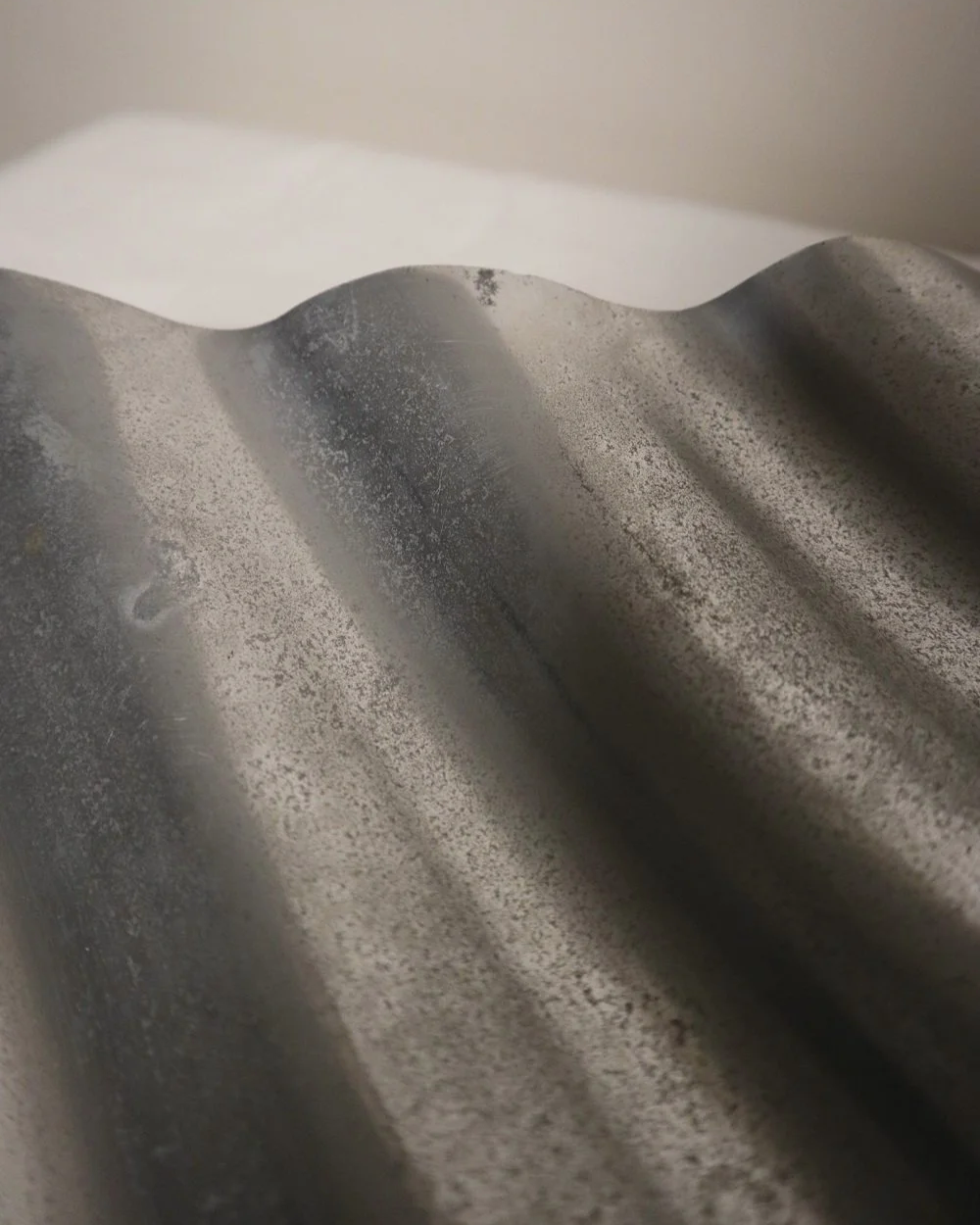 Large mid century, shiny cast aluminium triangular display dish with wavy edge.