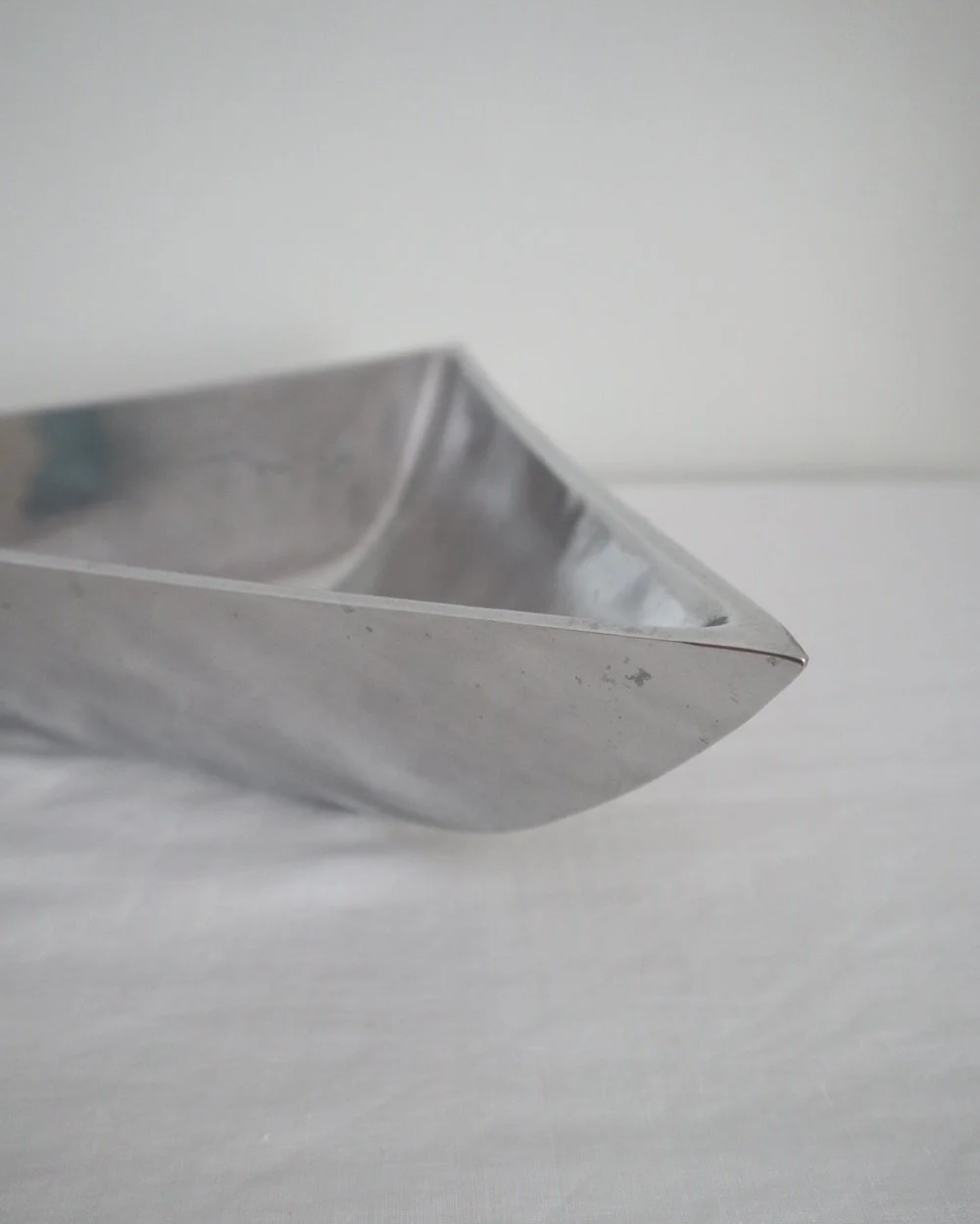 Solid shiny aluminium triangular Modernist style dish.